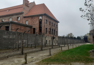 Budynek obozowy z czerwonej cegły za murem